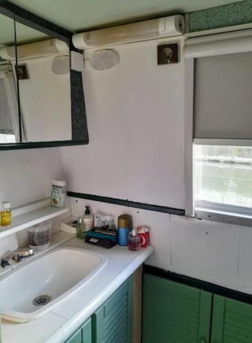 une petite cuisine avec un évier et une fenêtre dans l'établissement Studio bateau Narbonne, à Narbonne