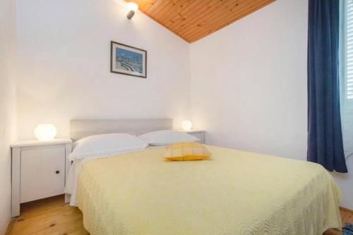 ein Schlafzimmer mit einem Bett mit gelbem Kissen darauf in der Unterkunft Apartment Burica in Primošten