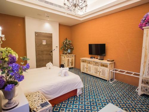 a hotel room with a bed and a tv at Anna King Hotel in Chiayi City