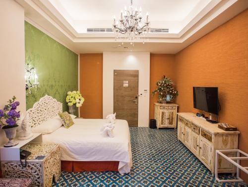 a hotel room with a bed and a tv at Anna King Hotel in Chiayi City