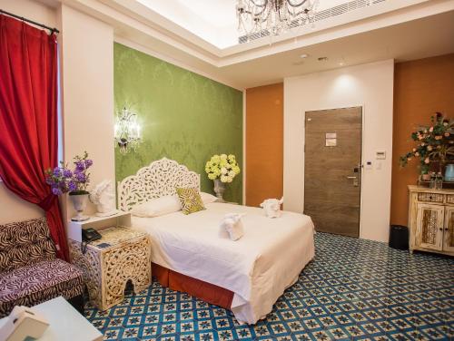 a hotel room with a bed and a chair at Anna King Hotel in Chiayi City