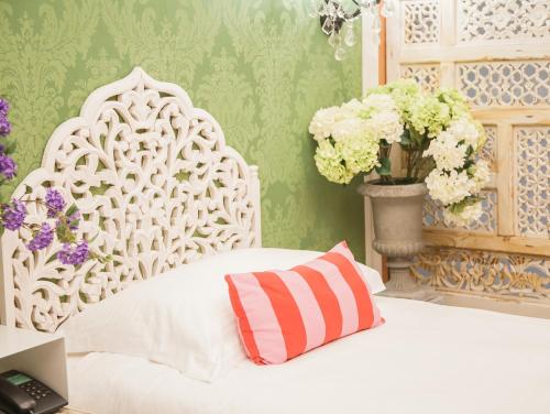 a white bed with a pillow and flowers in a room at Anna King Hotel in Chiayi City