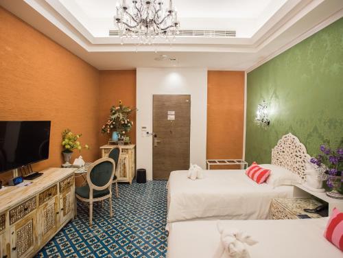 a hotel room with two beds and a flat screen tv at Anna King Hotel in Chiayi City