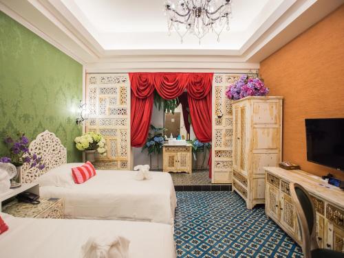 a hotel room with two beds and a tv at Anna King Hotel in Chiayi City