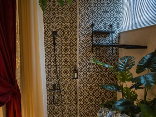 a shower in a room with a patterned wall at Anna King Hotel in Chiayi City