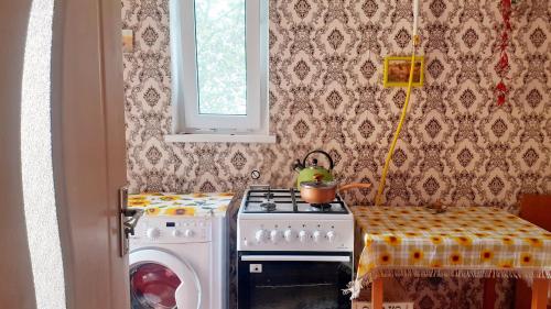 eine Küche mit einem Herd und einer Waschmaschine in der Unterkunft SION In Ulmu in Ulmu