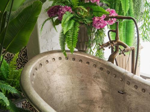 a large metal sink with a vase of flowers at Anna King Hotel in Chiayi City