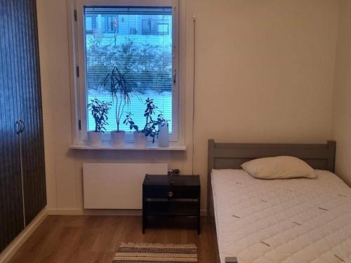 1 dormitorio con 1 cama y una ventana con plantas en Holiday home BONÄSSUND 