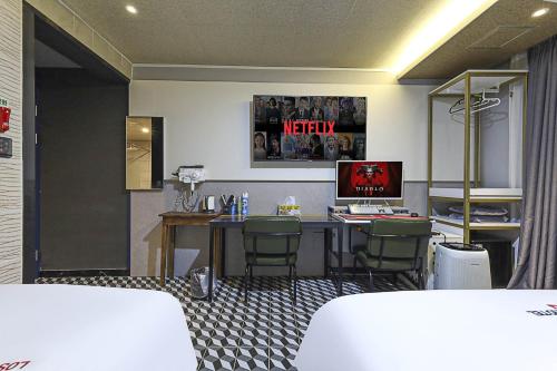 a room with a desk with a computer and chairs at Z Hotel in Cheongju