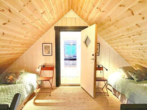 um quarto no sótão com 2 camas e uma porta em Holiday home BORGHOLM XIX em Borgholm