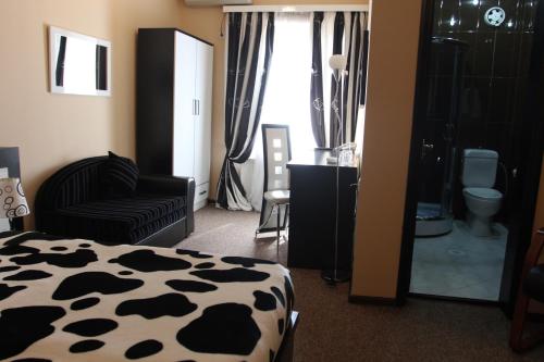 a bedroom with a cow print bed and a bathroom at Hotel Diplomat in Tbilisi City