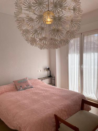 1 dormitorio con 1 cama con una lámpara de araña grande en H&H Suite El Santisimo, en Granada