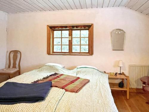 een slaapkamer met een bed, een tafel en een raam bij Holiday home ANNEBY in Aneby