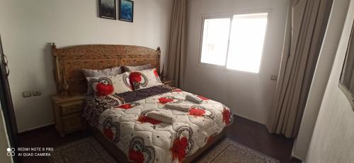 a bedroom with a bed with red birds on it at شقة في اقامة in Essaouira