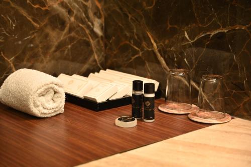 een houten tafel met twee flessen en een handdoek bij Hotel Krinoscco in Ayodhya