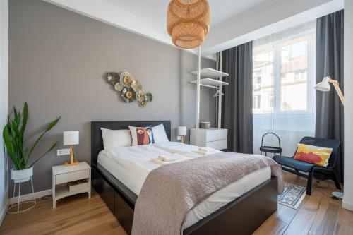 a bedroom with a bed and a chair in it at Elegant Getaway Near Iconic Eagles' Bridge in Sofia