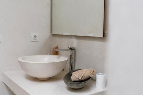 a bathroom with a bowl sink and a mirror at Villa Alba, Berawa Beach in Canggu