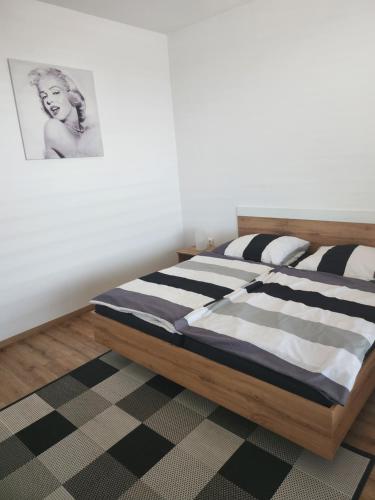 a bedroom with a bed with a picture on the wall at Meridiem byt in Topoľčany