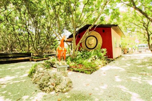 una pequeña casa con una estatua en un jardín en Exclusive Lake Tiny House in Beautiful Japanese Garden, en Homestead