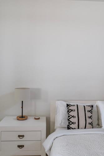 a bedroom with a bed and a nightstand with a lamp at Villa Alba, Berawa Beach in Canggu