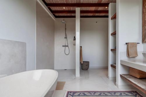 a bathroom with a white tub and a sink at Villa Alba, Berawa Beach in Canggu