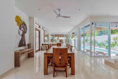 a dining room with a table and chairs at Villa Alba, Berawa Beach in Canggu