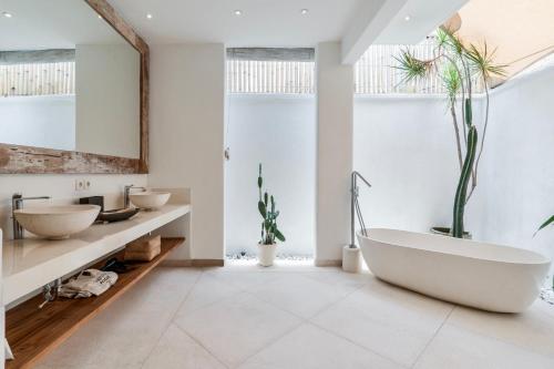 a bathroom with a large tub and two sinks at Villa Alba, Berawa Beach in Canggu
