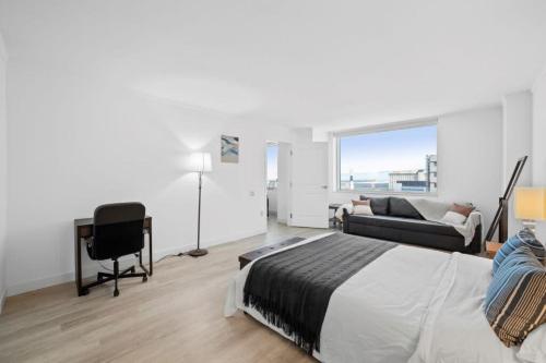 1 dormitorio con cama, escritorio y sofá en Bold Boardwalk 2BR 3BA Condo by CozySuites, en Atlantic City