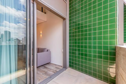 a bathroom with green tiles on the wall at Loft Duplex Metrô Vila Madalena NOVO E EQUIPADO in Sao Paulo