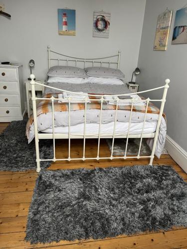 1 cama blanca en un dormitorio con alfombra en Cliftonville House, en Whitstable