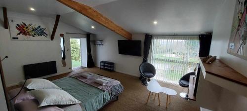 1 dormitorio con cama verde y ventana grande en chambre Lilas Domaine Cap de Coste, en Saint-Frajou