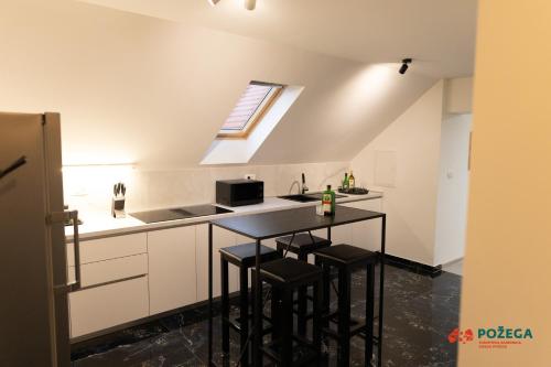 a kitchen with a table and some stools in it at Apartment Eden in Požega