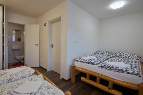 a room with two beds and a bathroom at Chalupa u rybára s Wellness a detským ihriskom in Liptovský Trnovec
