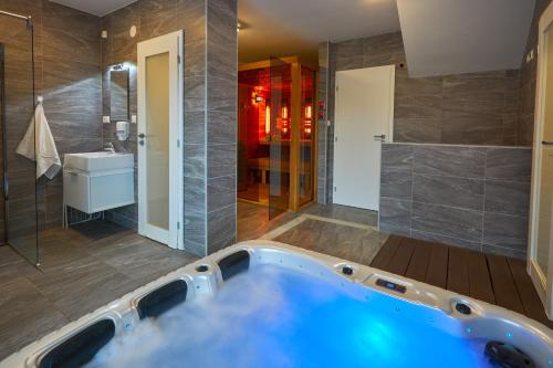a large bathroom with a tub and a sink at Chalupa u rybára s Wellness a detským ihriskom in Liptovský Trnovec