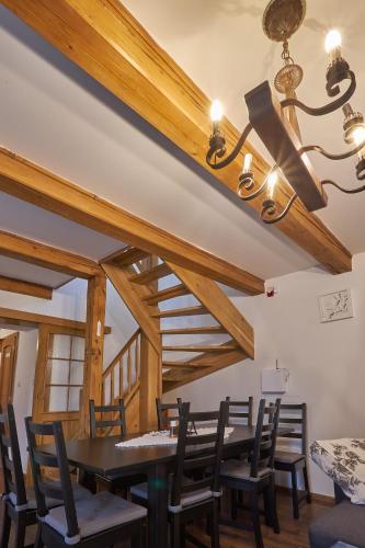 a dining room with wooden ceilings and a table and chairs at Chalupa u rybára s Wellness a detským ihriskom in Liptovský Trnovec