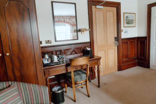 a room with a wooden desk with a chair at Royal Hotel in Stornoway