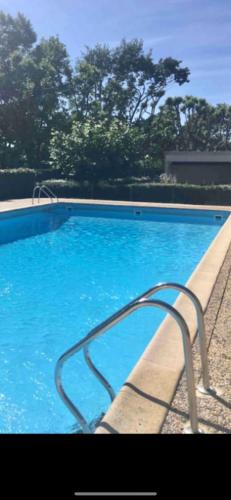 une grande piscine bleue avec une main courante en métal dans l'établissement Studio du port avec terrasse, parking privatif, piscine dans résidence , wifi, ménage compris, à Andernos-les-Bains
