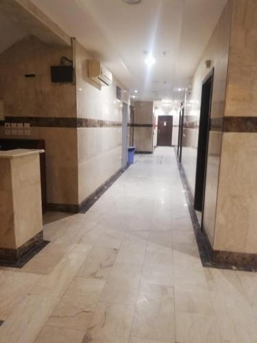 an empty hallway in a building with tile floors at مبني الششة 5 in Al Khansāk
