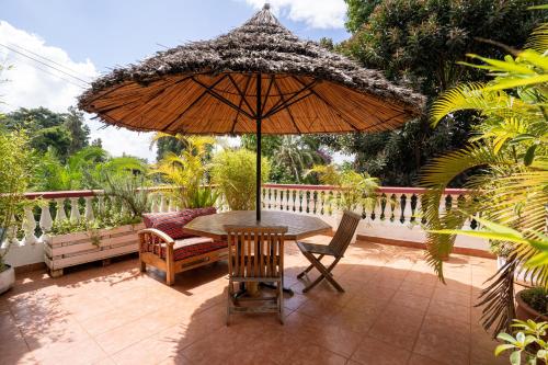 a table and chairs and an umbrella on a patio at Bonsai Villa in Nairobi