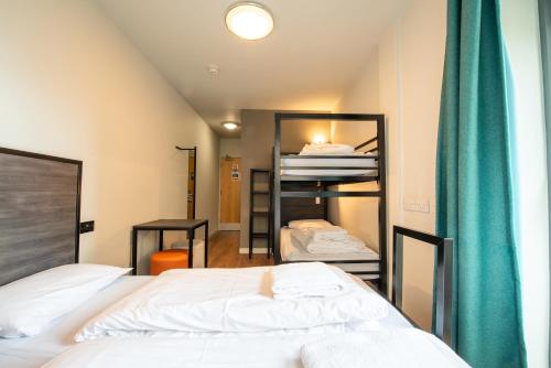 a small bedroom with a bed and a room with a mirror at a&o Edinburgh City in Edinburgh