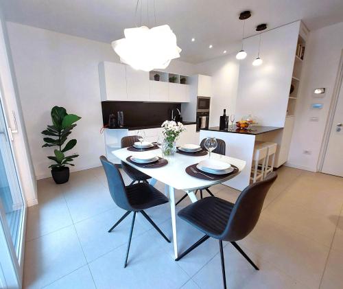 a kitchen and dining room with a white table and chairs at Casa Aurora in San Michele allʼAdige
