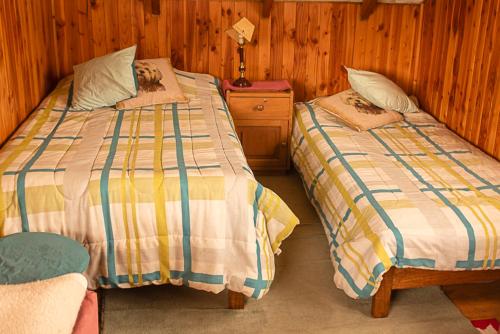 two beds sitting next to each other in a bedroom at Coñaripe alojamiento in Panguipulli