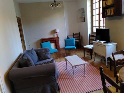 un salon avec un canapé, des chaises et une table dans l'établissement Gîte 5 pers en Périgord, à Siorac-en-Périgord