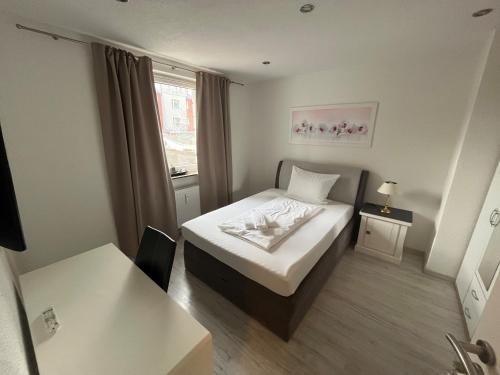 a small room with a bed and a window at Pension Donau in Hannover