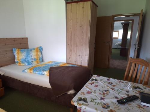 a bedroom with a bed and a table and a table and a mirror at Berggasthaus Kraxenberger in Brannenburg