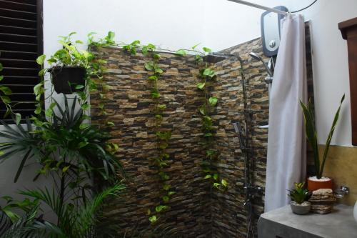 a brick wall with green plants on it at Leel’s Safari Cottage in Udawalawe