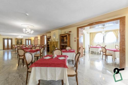 ein Esszimmer mit roten Tischen und Stühlen in der Unterkunft HOTIDAY Hotel Olbia in Olbia