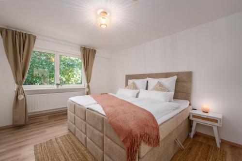a bedroom with a large bed and a window at Entspannung im Boho-Flair: Sauna & Whirlpool in Schwerte
