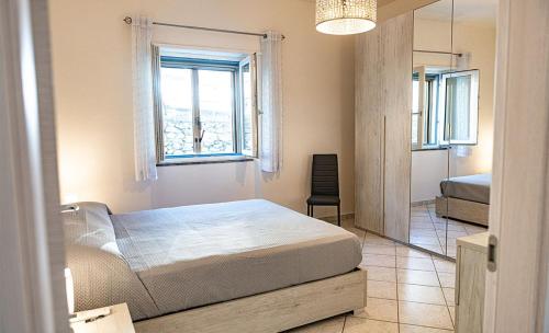 a bedroom with a bed and a window and a mirror at La Casa del Panza con vista mare in Isola del Giglio