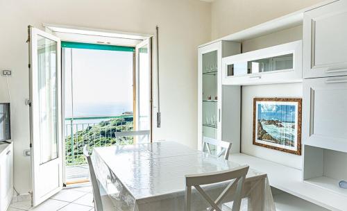 a dining room with a table and chairs and a window at La Casa del Panza con vista mare in Isola del Giglio